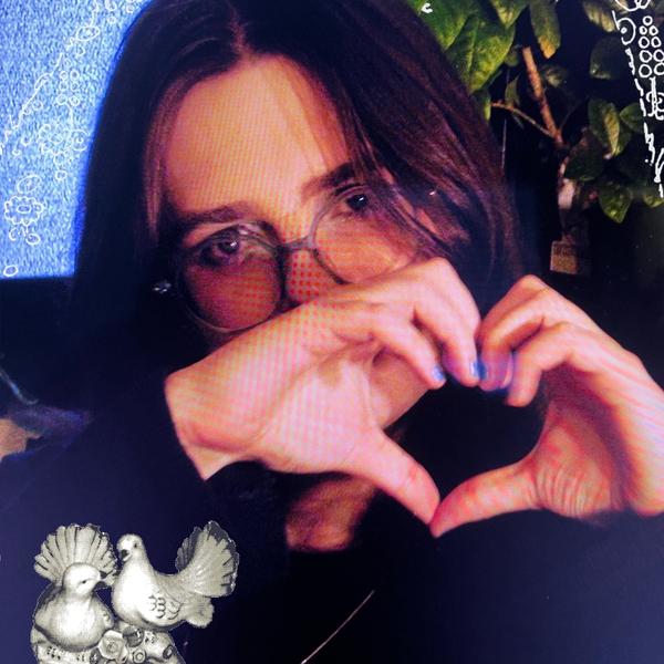 a digital photo of a person giving the viewer a heart sign with their hands.