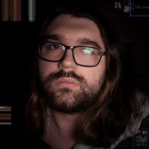 a photo of birbohex in a dark room. corrupted graphics are scattered across the edges of the image.